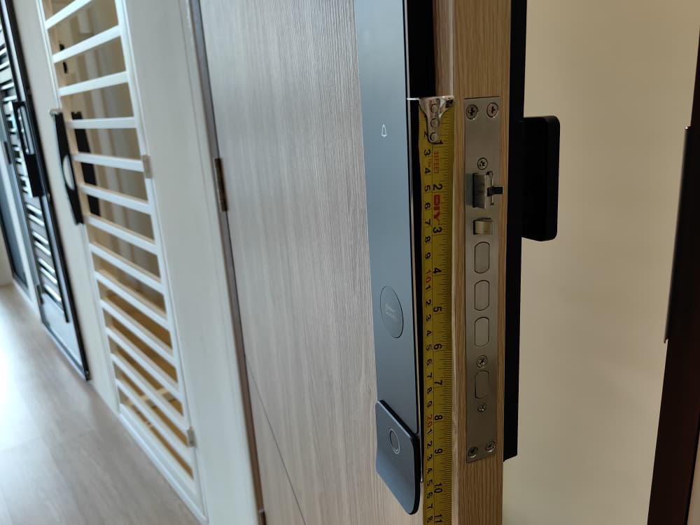 Side view of a digital lock installed on a main door with a grille in front